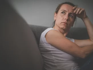 långtidsarbetslös kvinna sitter hemma i sin soffa