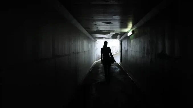 Kvinna lämnas vind för våg, går i väg genom tunnel.