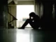 Person sitter i en mörk trappuppgång, deprimerad