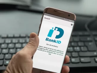 Man håller i en telefon med BankID synligt.