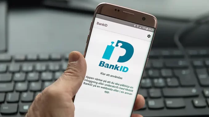 Man håller i en telefon med BankID synligt.